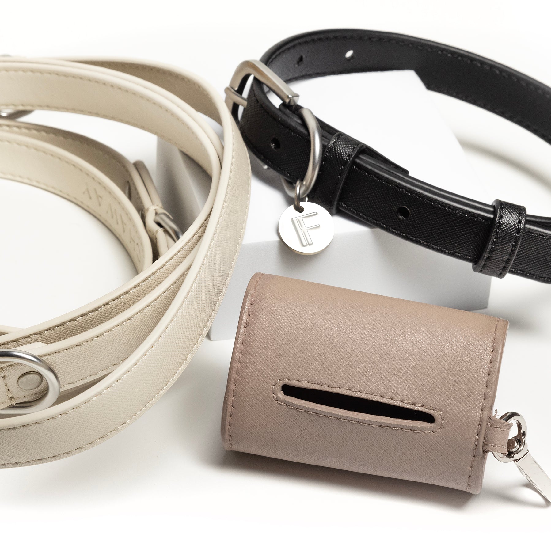 Photo showing three products that FETCHAWAY carries, a waste bag holder, a leash and a dog collar